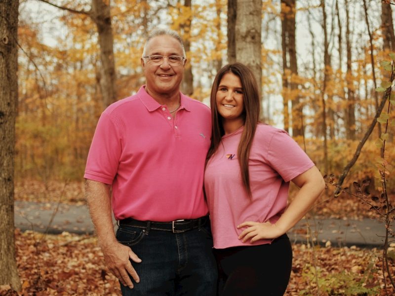 a man and woman posing for a picture in the woods