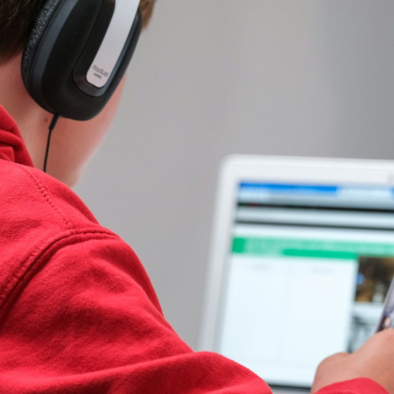 person in red shirt wearing black and gray headphones