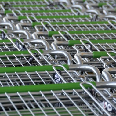 Persoon bij de kassa van een supermarkt die boodschappen afrekent