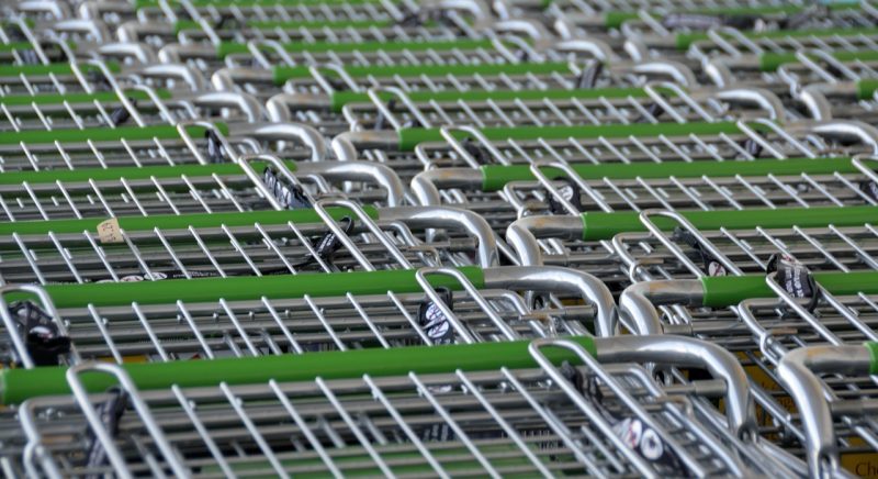 Persoon bij de kassa van een supermarkt die boodschappen afrekent