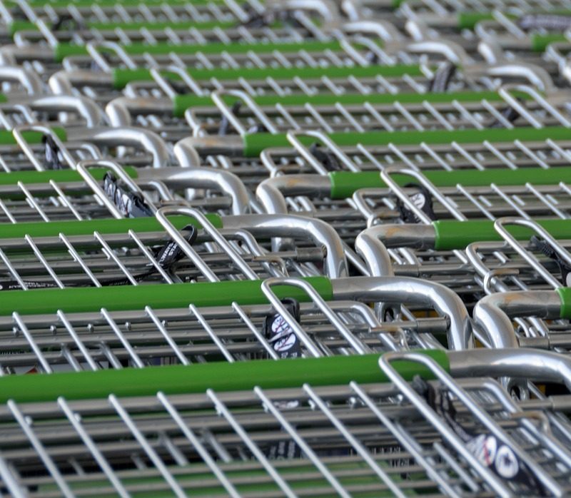 Persoon bij de kassa van een supermarkt die boodschappen afrekent