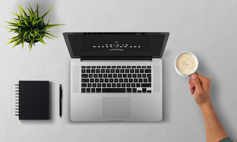 Persoon die achter een laptop thuis werkt aan digitale producten