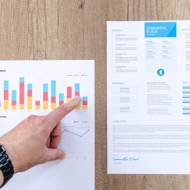 Persoon die beleggingskosten vergelijkt op laptop met grafieken