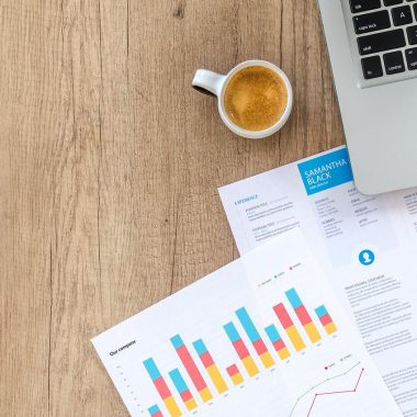 Persoon die financiële documenten doorleest aan een bureau