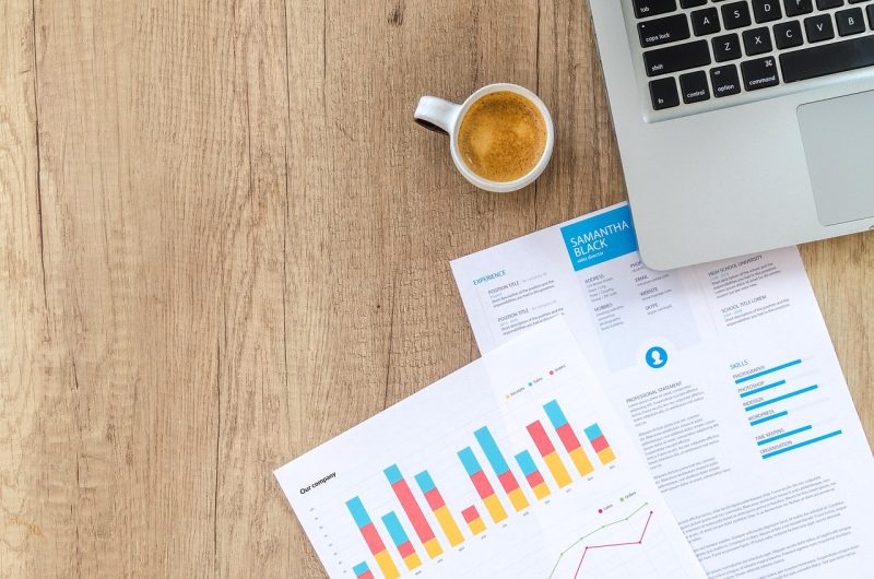 Persoon die financiële documenten doorleest aan een bureau