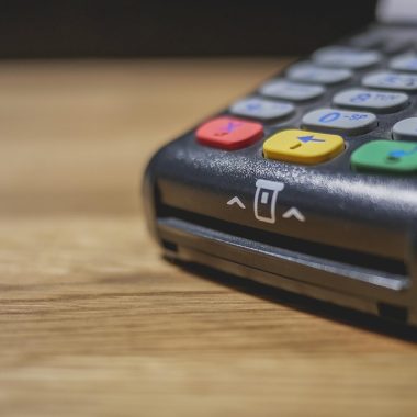 Persoon betaalt contactloos met smartphone bij een betaalterminal in een winkel