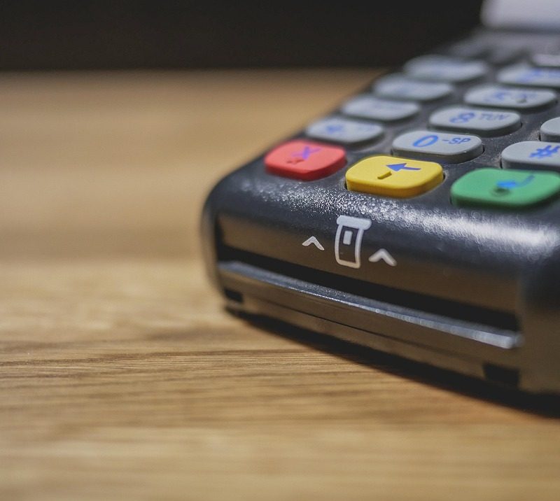 Persoon betaalt contactloos met smartphone bij een betaalterminal in een winkel