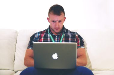 Persoon die thuis achter een laptop werkt en bijverdiensten bijhoudt