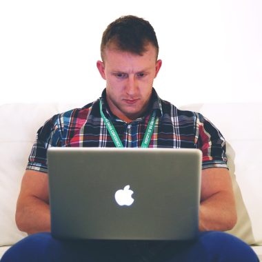 Persoon die thuis achter een laptop werkt en bijverdiensten bijhoudt