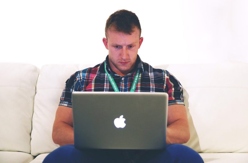 Persoon die thuis achter een laptop werkt en bijverdiensten bijhoudt