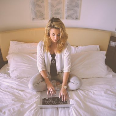 Persoon werkt 's avonds thuis achter laptop aan een side hustle
