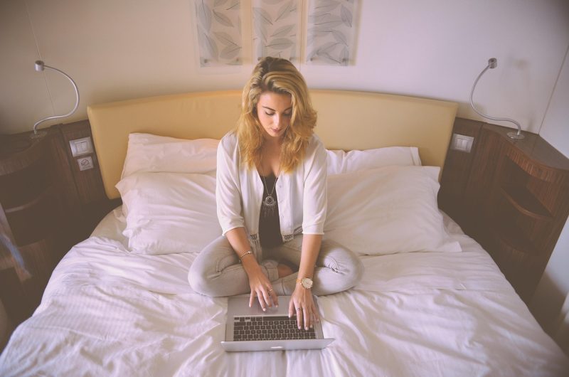 Persoon werkt 's avonds thuis achter laptop aan een side hustle