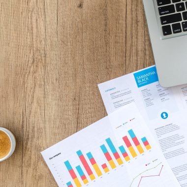 Persoon die financiële documenten doorkijkt aan een bureau