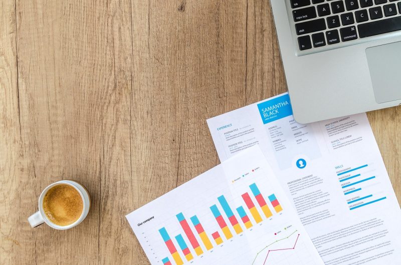 Persoon die financiële documenten doorkijkt aan een bureau