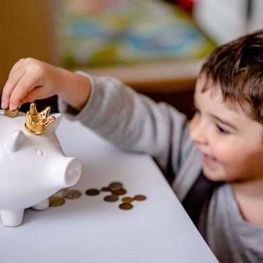 Ouder en kind zetten geld in een spaarpot als symbool voor beleggen voor je kind