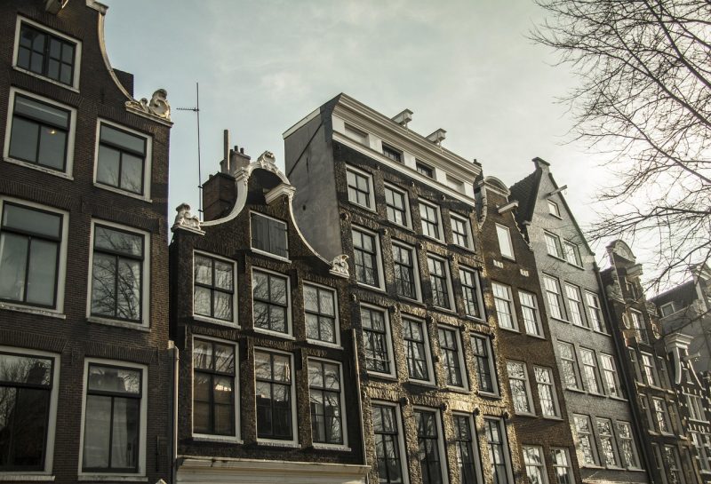 Nederlands gezin dat samen financiële documenten en een laptop bekijkt aan de keukentafel