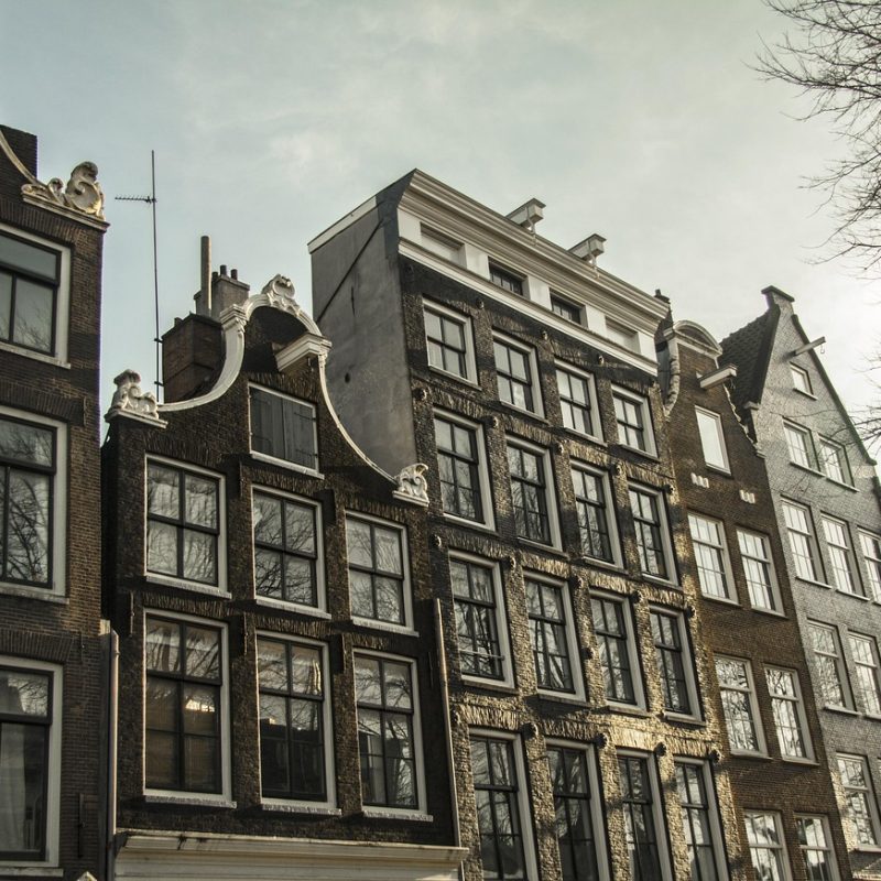 Nederlands gezin dat samen financiële documenten en een laptop bekijkt aan de keukentafel